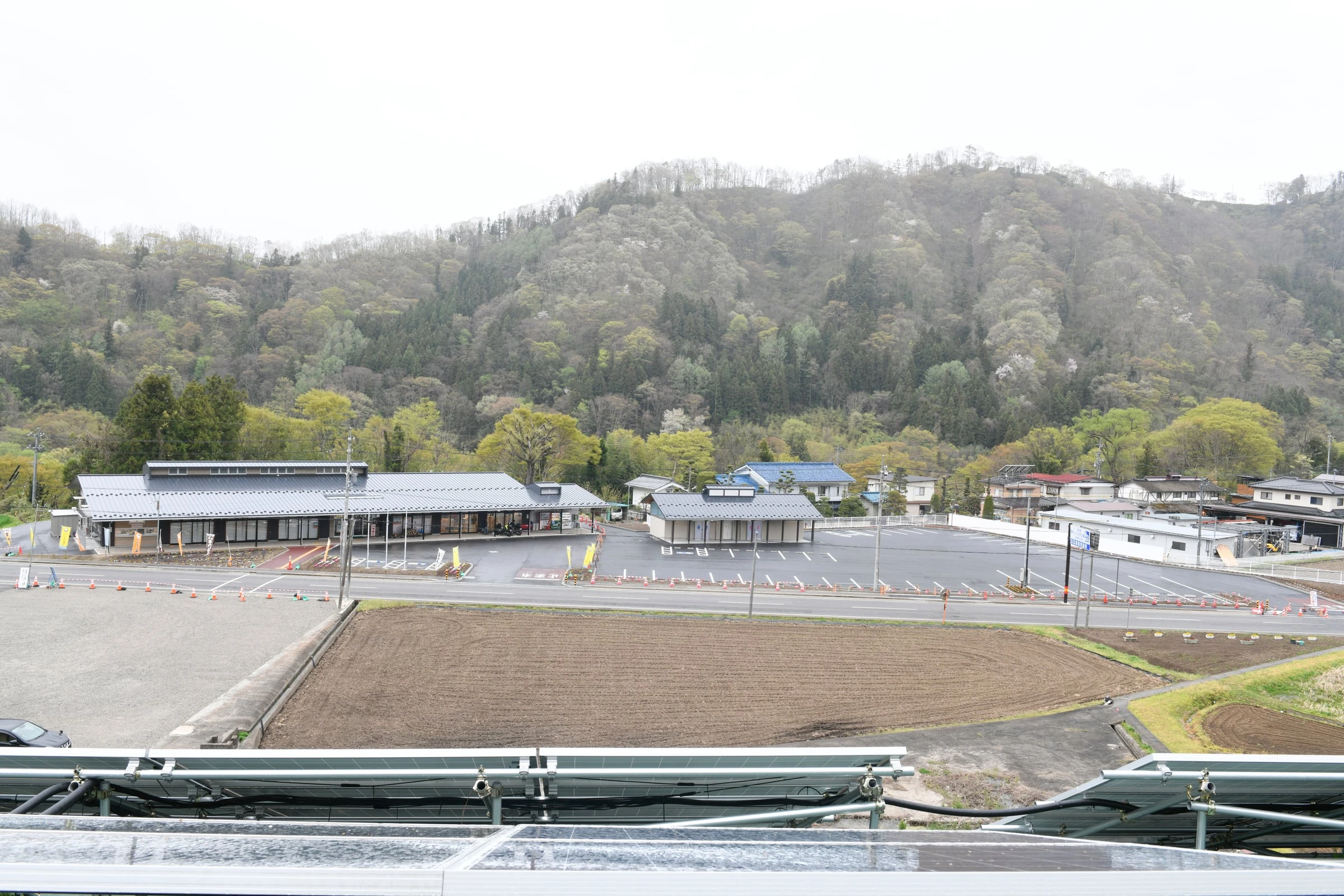 高い位置から見た道の駅の全景。駐車場と物産館、背後の山