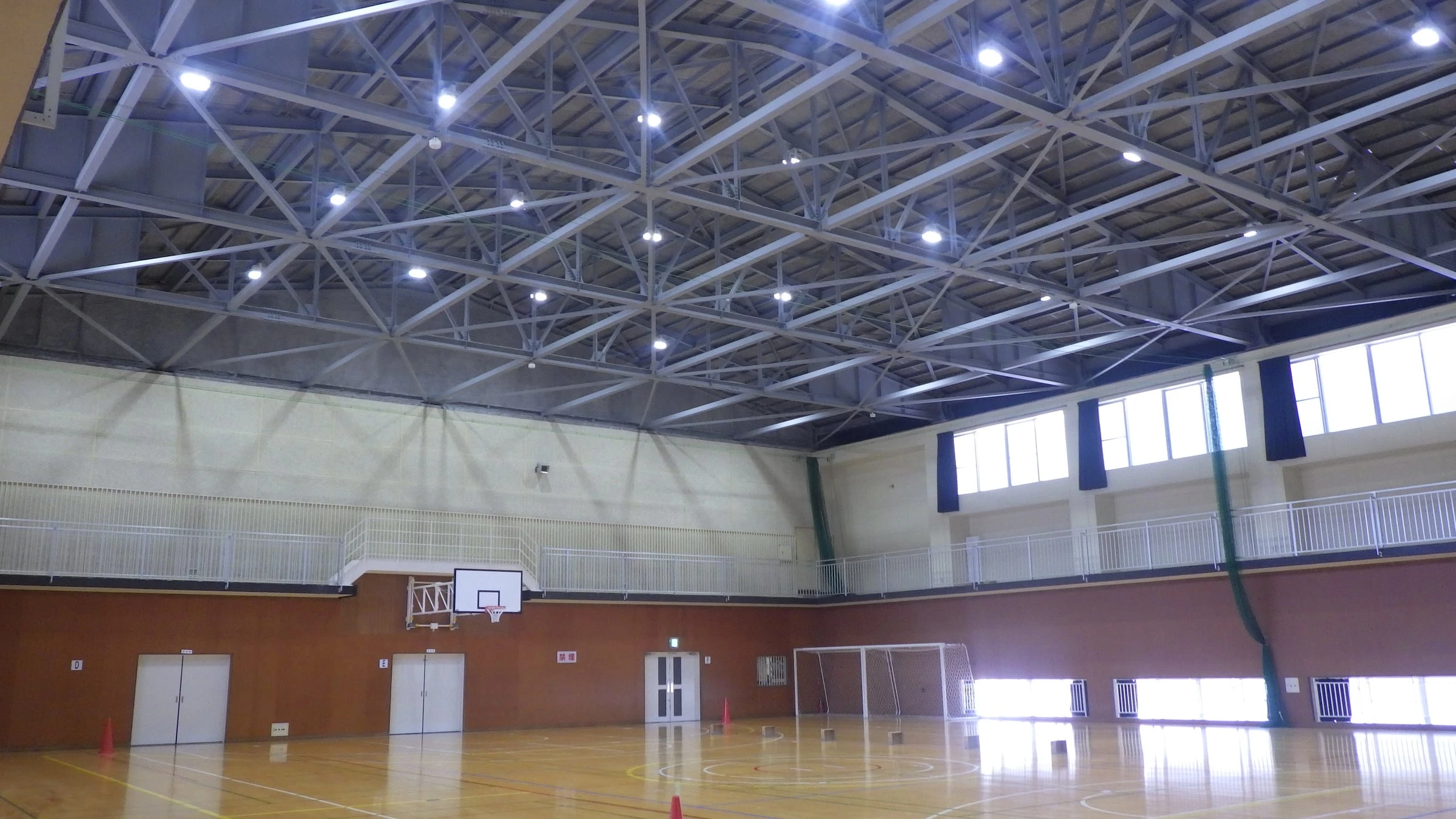 改修した体育館の内部。鉄骨の屋根組みと新しい照明