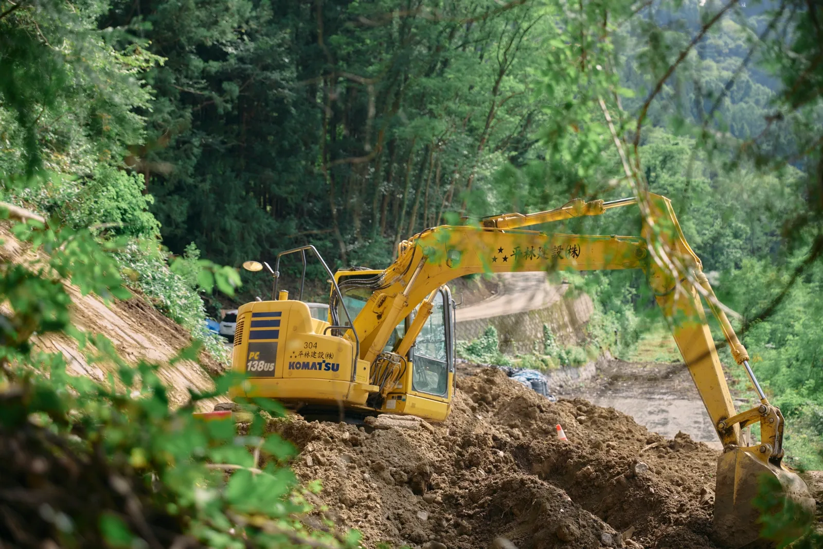 山腹の災害復旧現場で作業する重機