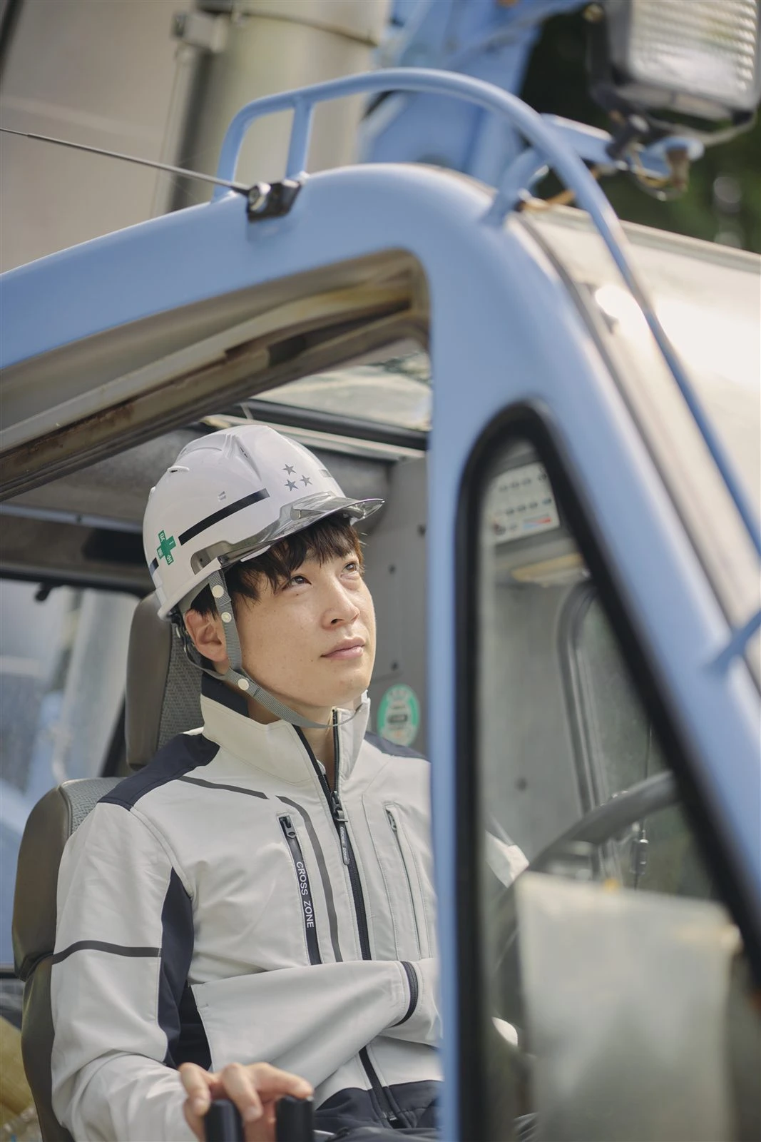クレーンの運転席に座る若手社員