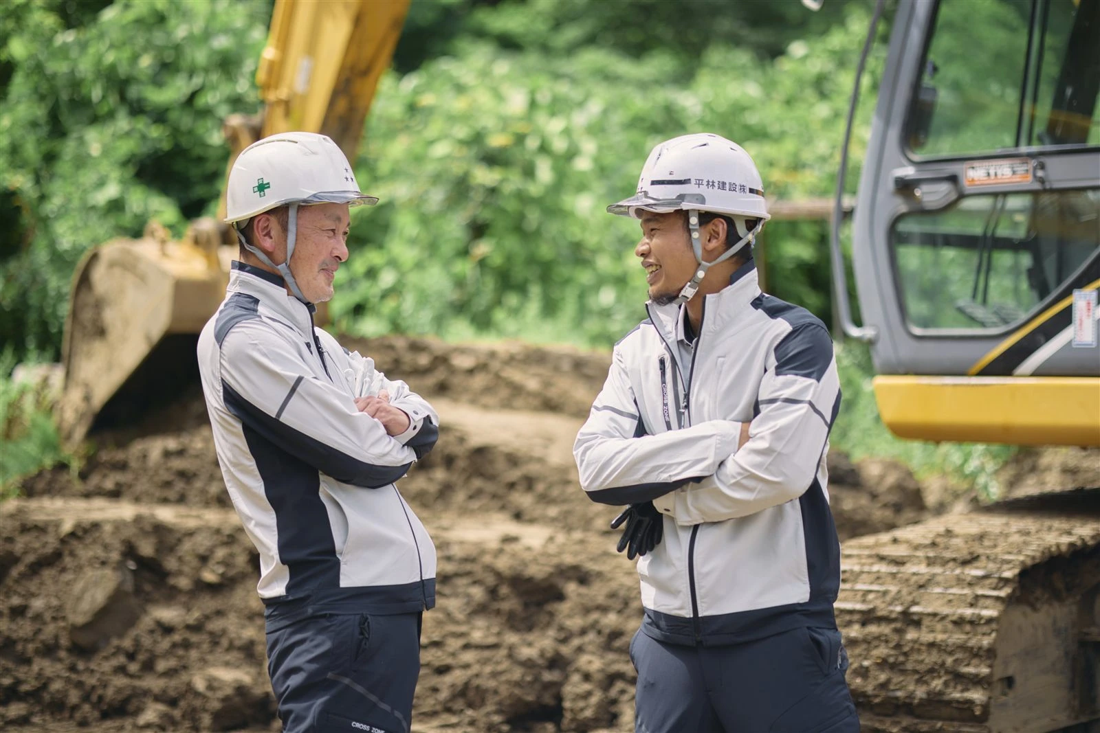 現場で向き合って話す2人の社員