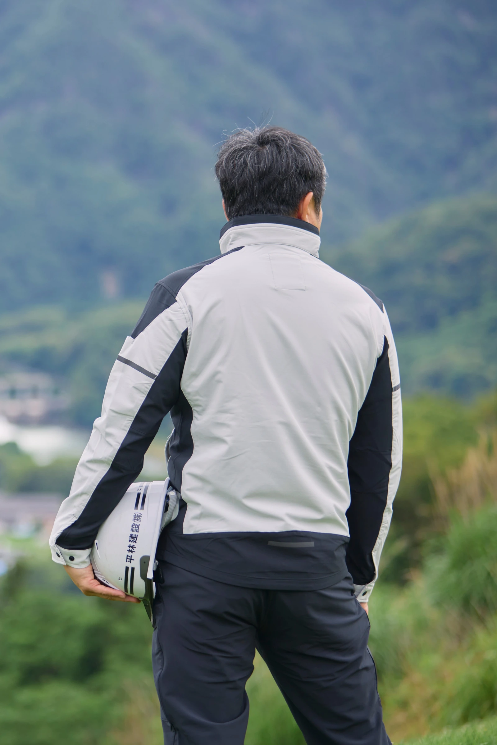 生坂村を見下ろす社員の後ろ姿