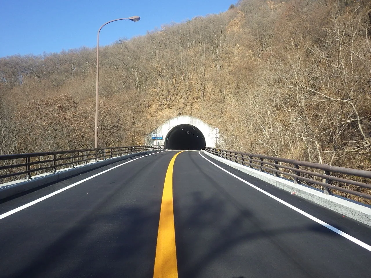 修繕を終えた橋の路面と、その先に続くトンネルの坑口