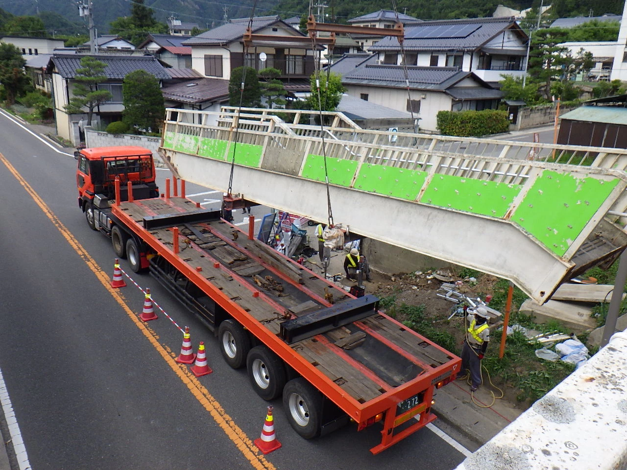 取り外した歩道橋の斜路を、道路脇のトレーラーへ積み込む作業
