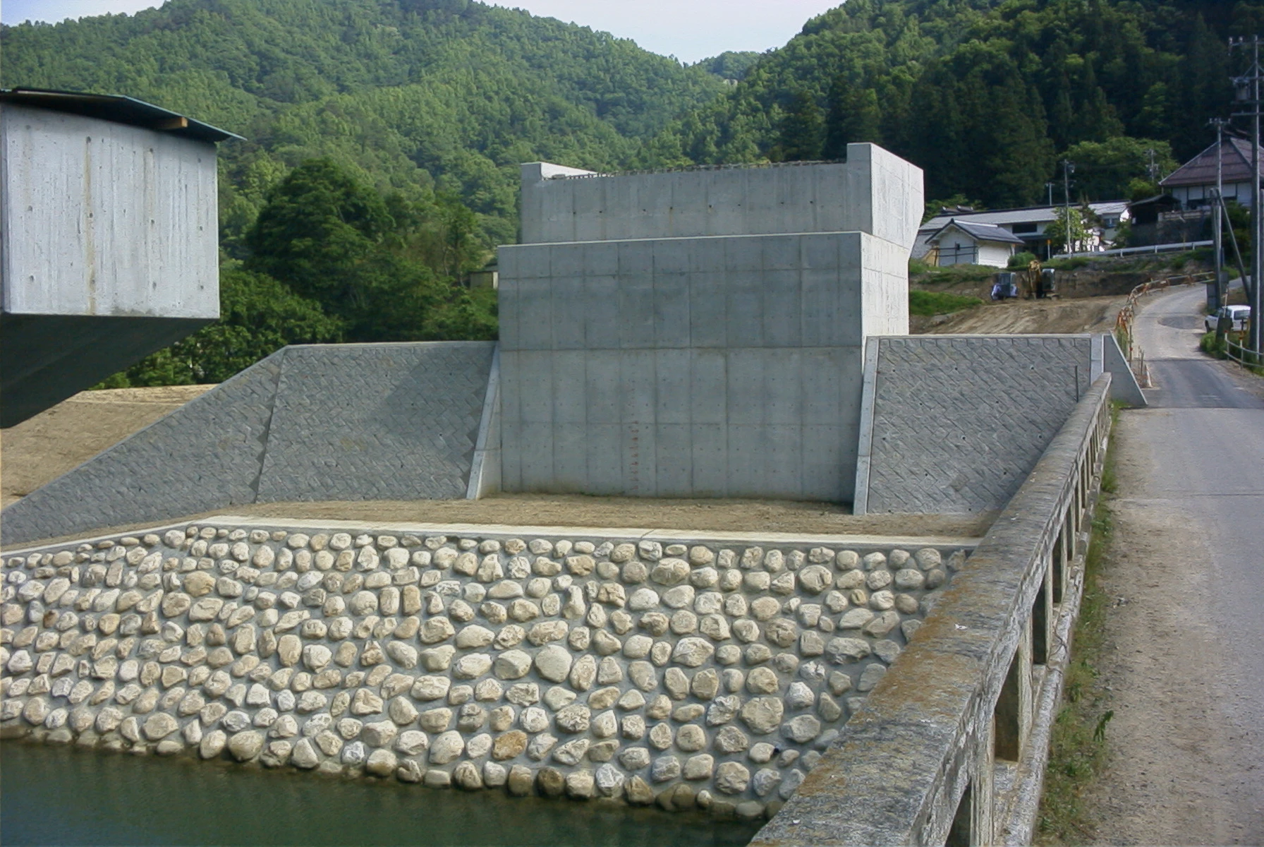 岸に築いたコンクリートの橋台と、その前面に積んだ玉石の護岸