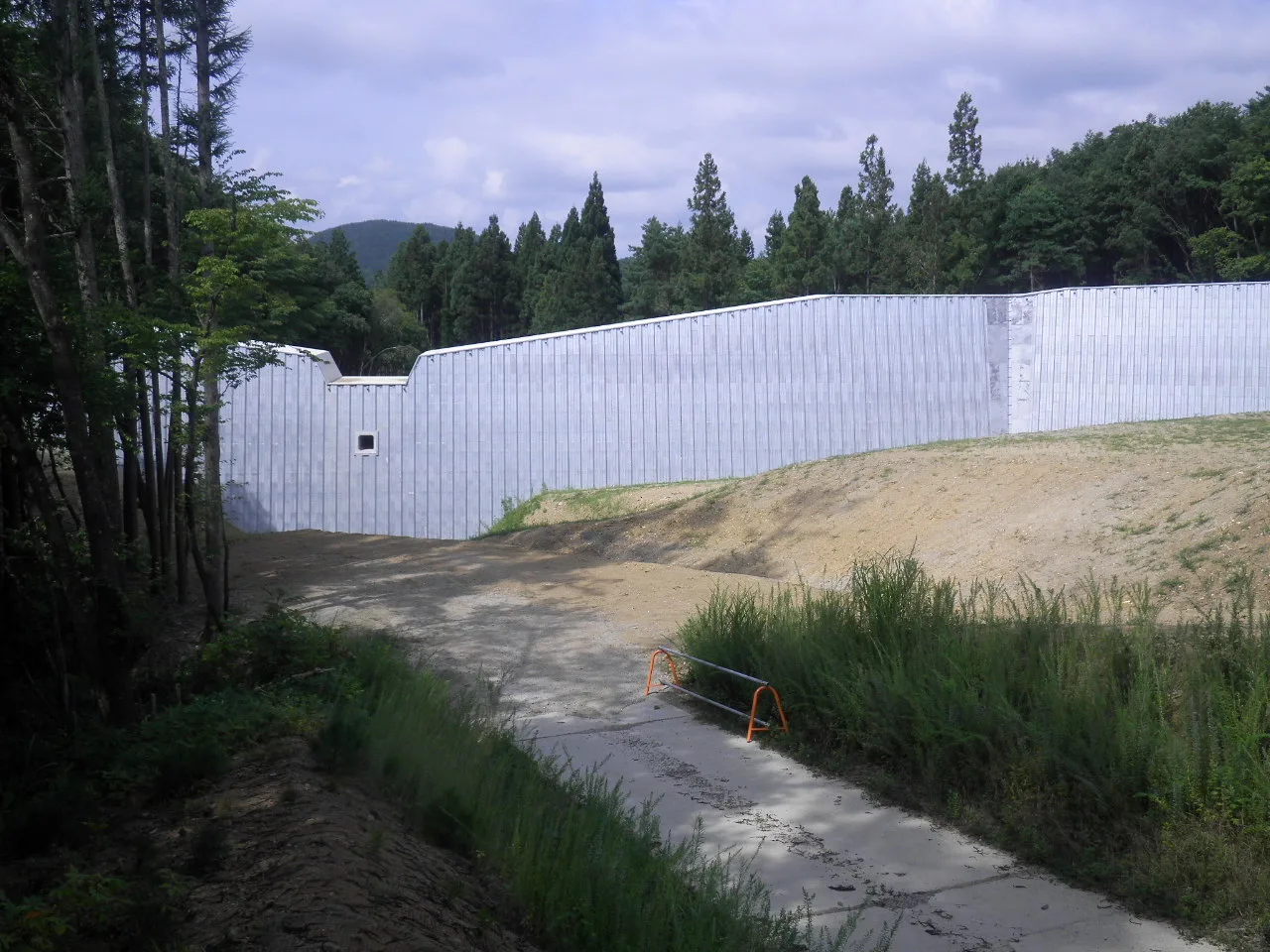 上流側から見た砂防堰堤の壁面と、その手前に広がる堆砂敷