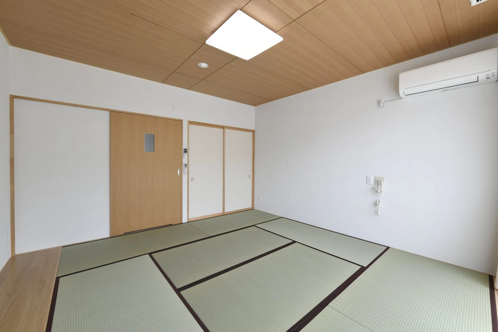 畳を敷いた居室。木目の天井と押し入れ