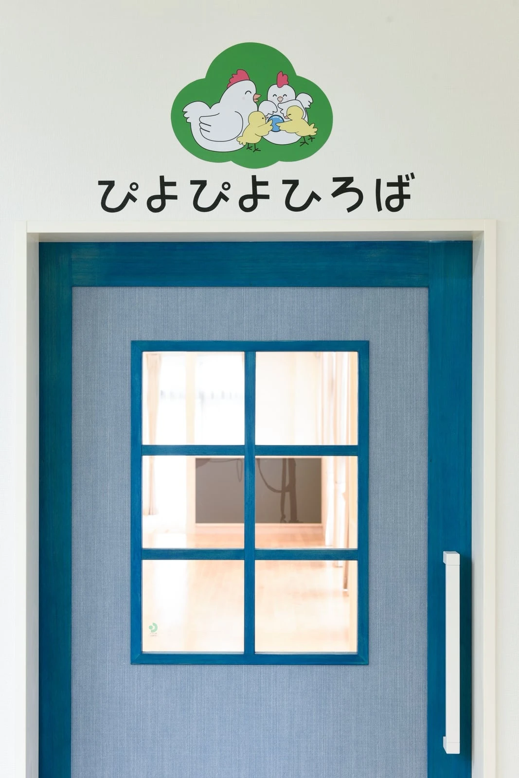 「ぴよぴよひろば」と掲げられた青い格子窓の扉