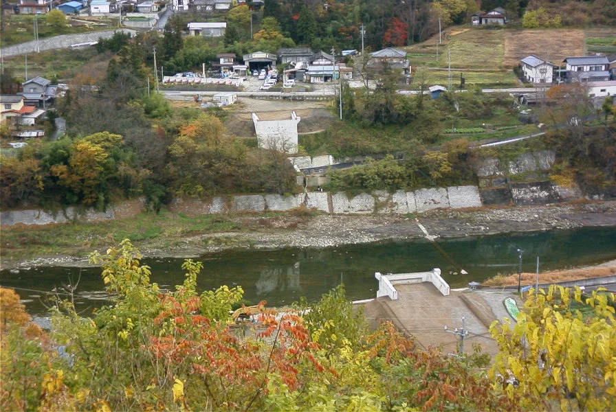 上空から見た、川沿いの集落と護岸（秋）