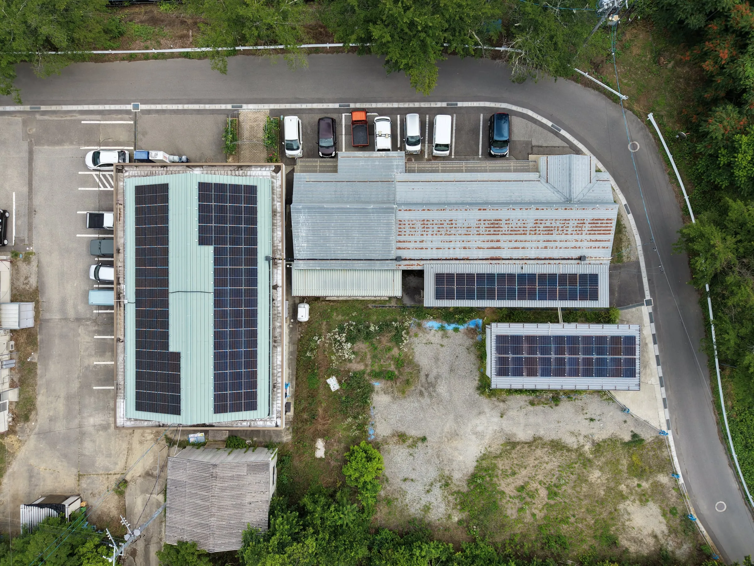 上空から見た、事務所棟の屋根と敷地に設けた太陽光パネル