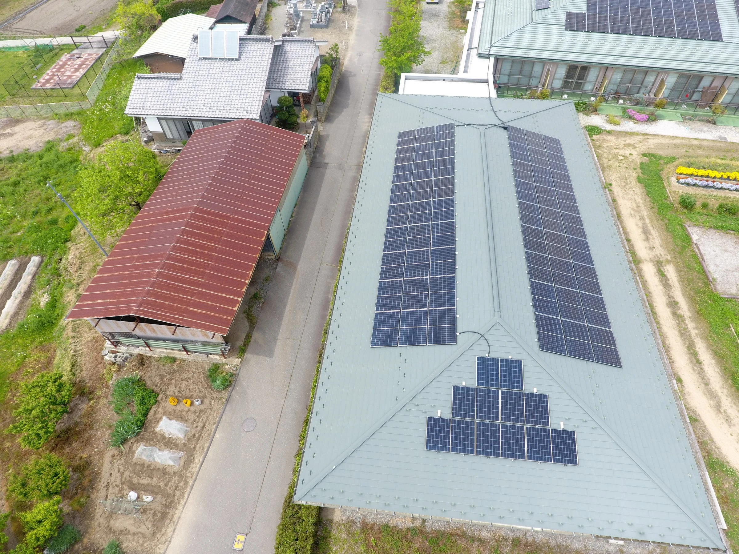 寄棟屋根に2列に並べた太陽光パネルと、下屋に置いた小さな一群