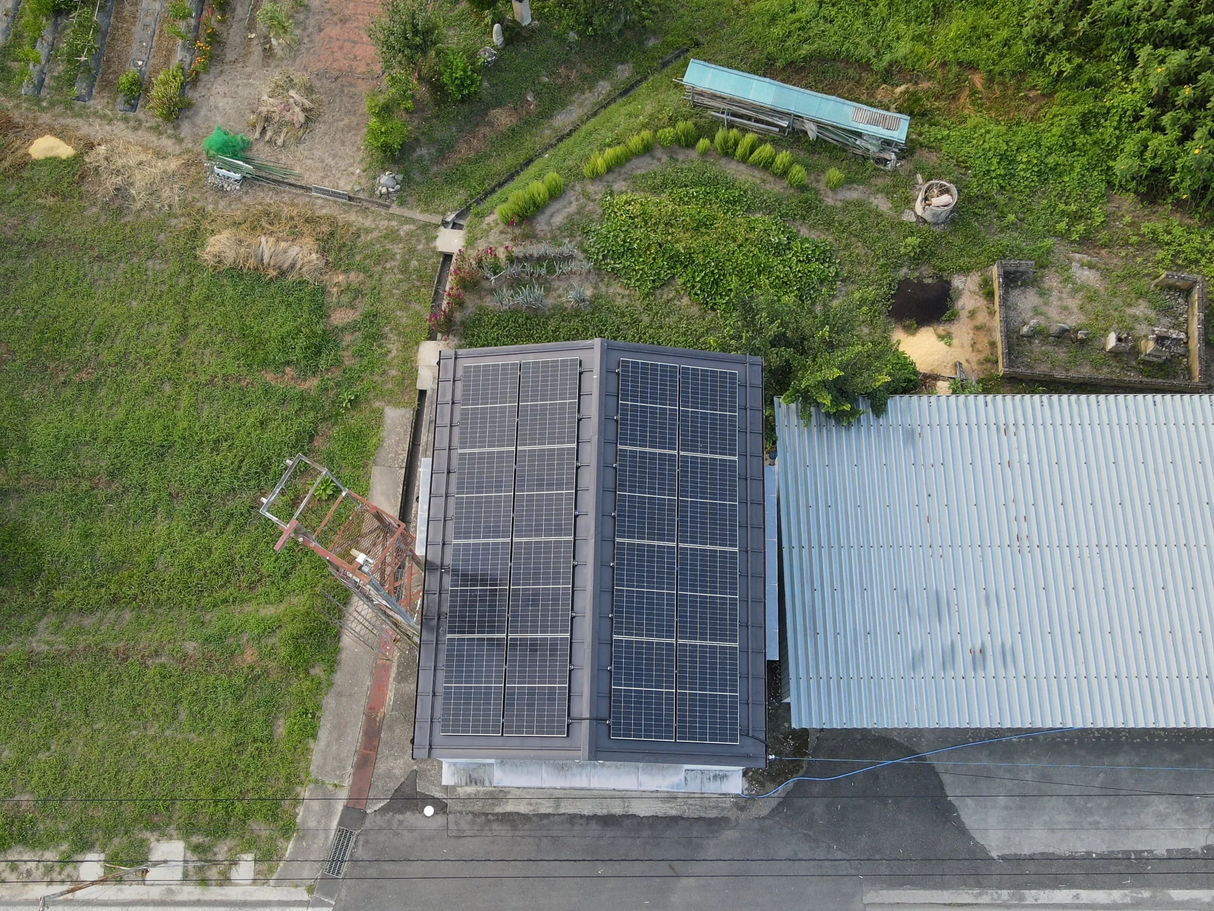 小さな建物の屋根いっぱいに並ぶ太陽光パネル