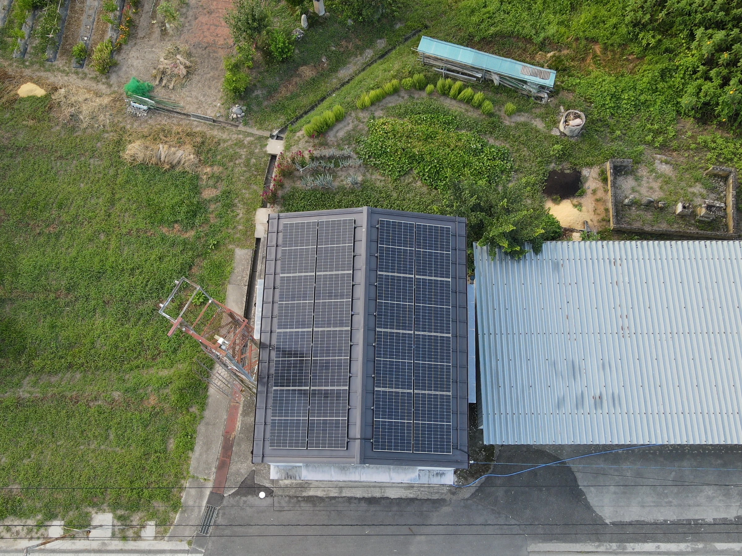 小さな建物の屋根いっぱいに並ぶ太陽光パネル