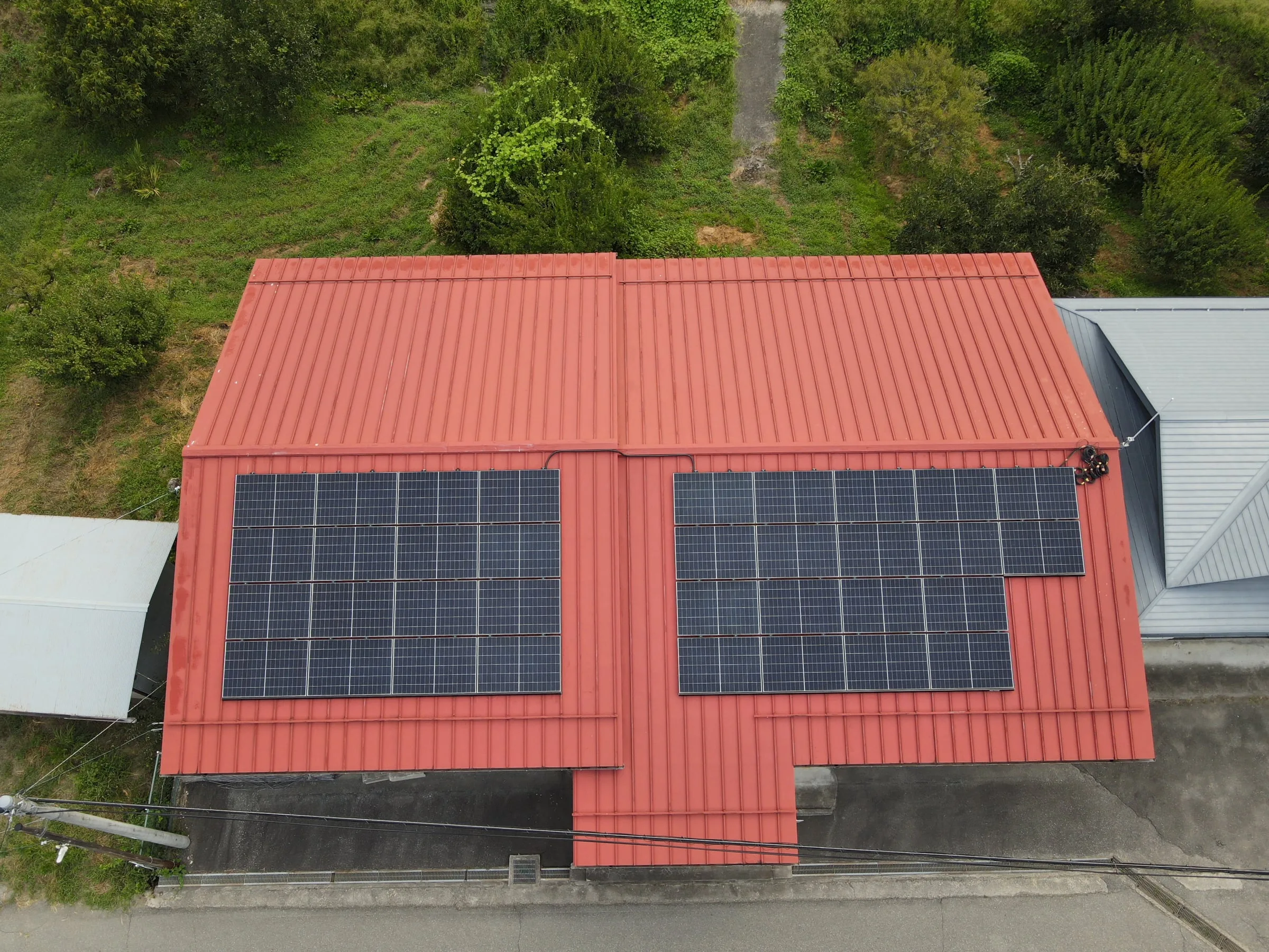 赤い屋根に、2つの群に分けて並べた太陽光パネル