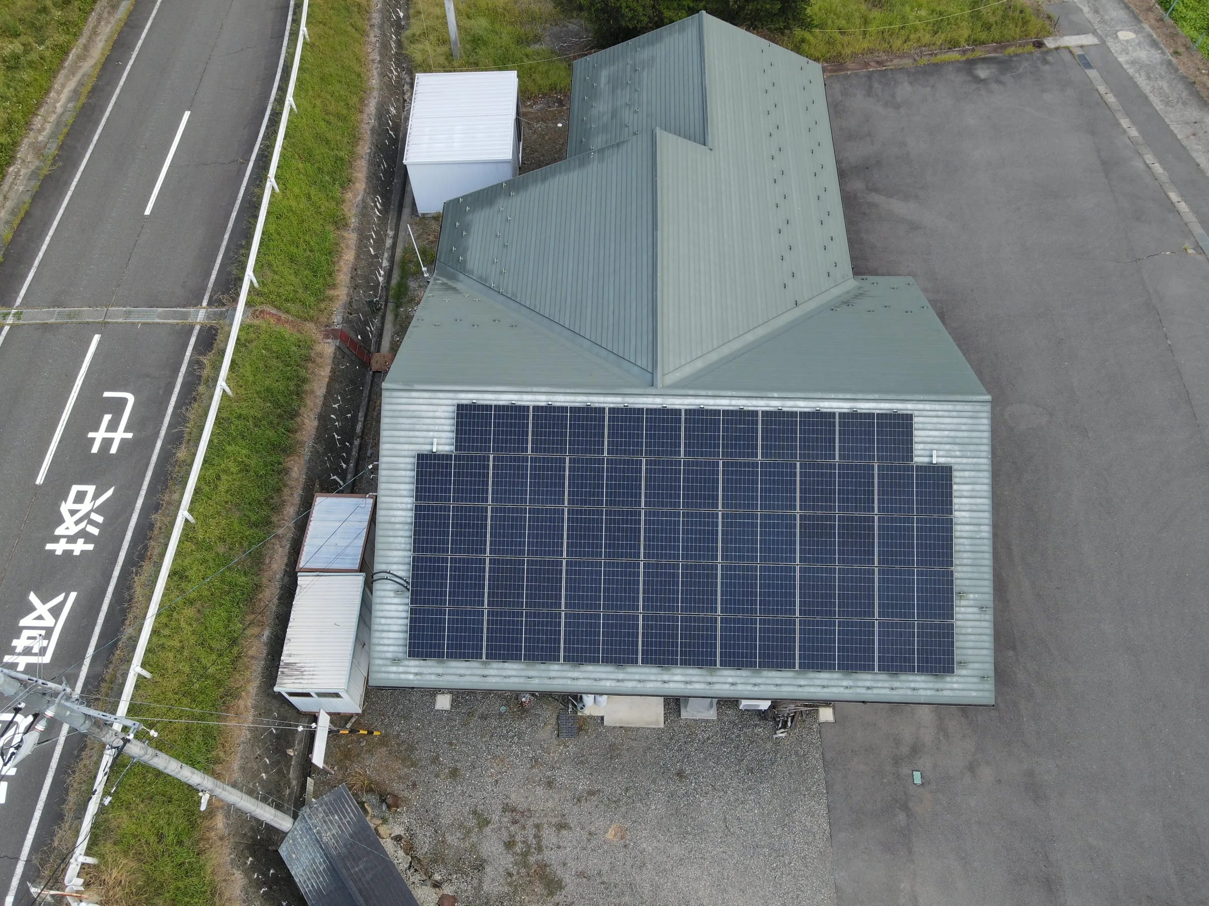 道路沿いの建物の屋根に並ぶ太陽光パネル